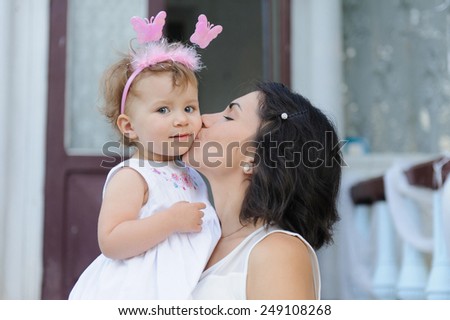 mother kissing daughter with butterflies on headband