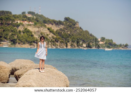 smiling woman in sunglasses holding dress skirt