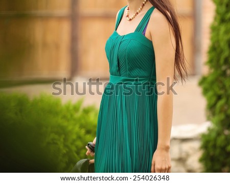 woman in elegant green dress in park