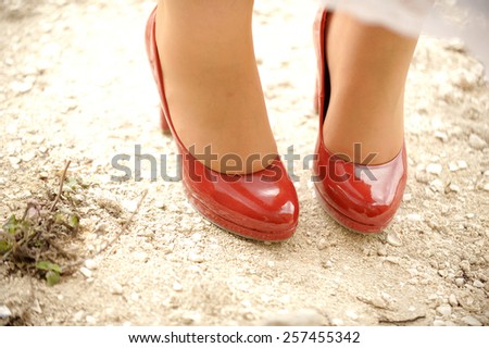 woman's feet in red shoes on ground