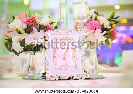 flowers and frame with table number on table