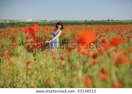 Attractive young woman having fun in a poppy field