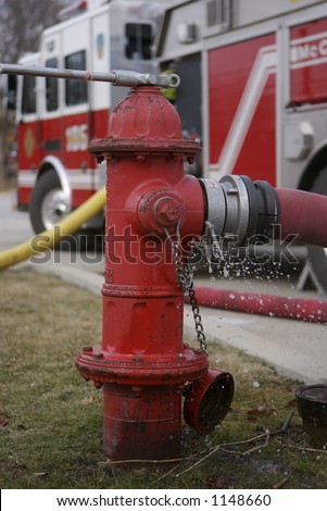 Fire Hydrant with Shallow Depth of Field firetruck in the background with water