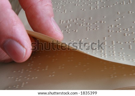 closeup shot of someone turning a Braille book page