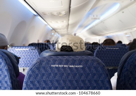 Fasten seat belt sign on the back of a seat from a commercial airliner.