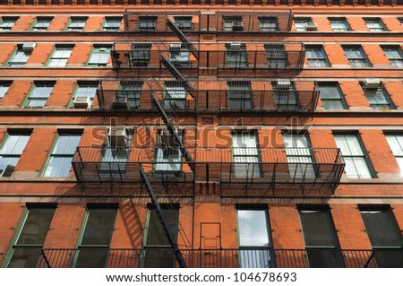 Facade of an old red brick downtown apartment building.
