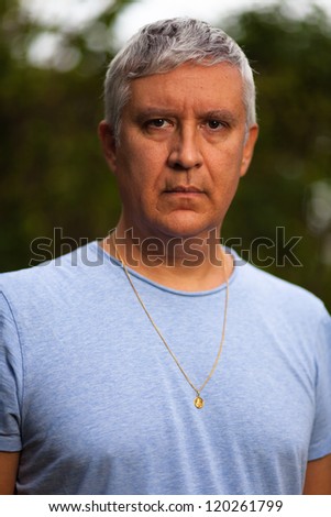 Handsome middle age man with salt and pepper hair in casual clothing outdoors.