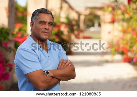 Handsome middle age Hispanic man in casual clothing outdoors.