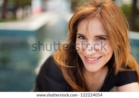 Attractive middle age woman in a outdoor fountain setting.