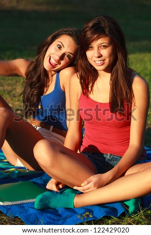 Beautiful multicultural young college women enjoying outdoor campus life.