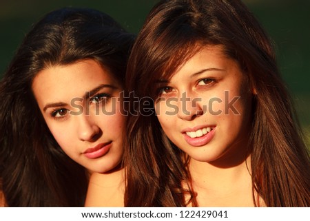 Beautiful multicultural young college women enjoying outdoor campus life.