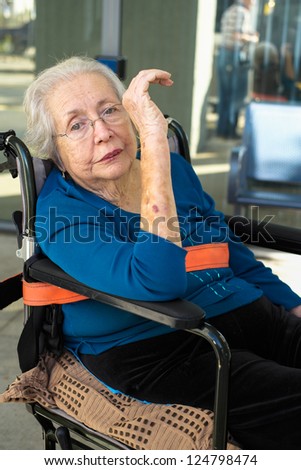 Elderly 80 plus year old woman portrait in a outdoor setting while being transported.