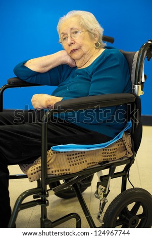 Elderly 80 plus year old woman portrait with a blue background.