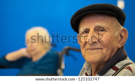 Elderly 80 plus year old man portrait with a blue background.