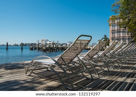 Row of white lawn chairs outdoors in a condo setting.