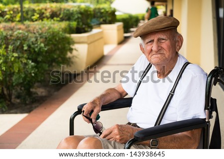 Elderly 80 plus year old man in a wheel chair outdoors.