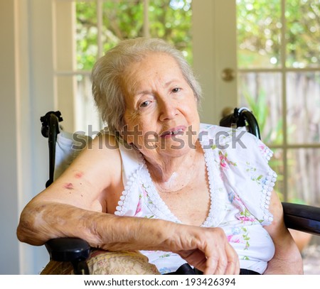 Elderly eighty plus year old woman in a wheel chair in a home setting.
