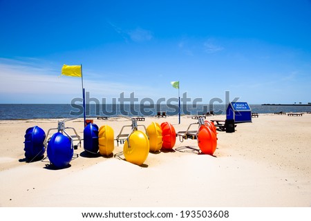 Gulf coast beach in Biloxi, Mississippi with water tricycles and lounge chairs.