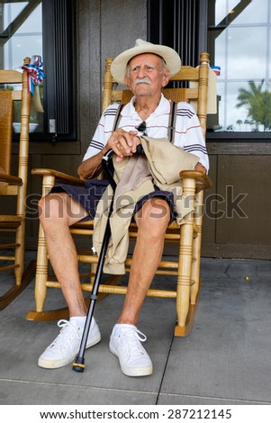 Elderly eighty plus year old man sitting on a rocking chair.