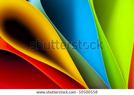 Macro and abstract image of colored card stock (blue,red,pink,yellow and green) with a tear drop or elliptical shape on a black background. Excellent image for business background.