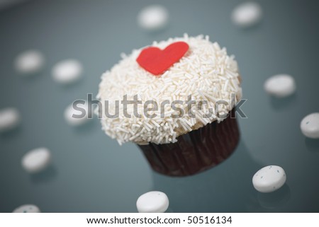 Valentines Day Gourmet Buttercream Cupcake on a gray background with chocolate mint candies.