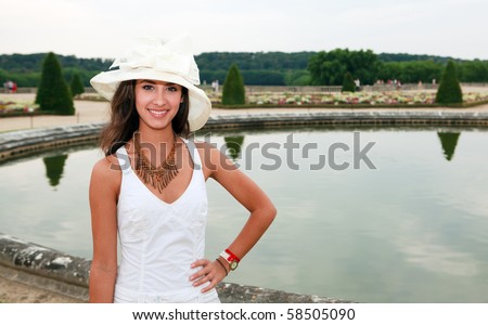 Beautiful young woman enjoying the Palace of Versailles Gardens in Paris, France.