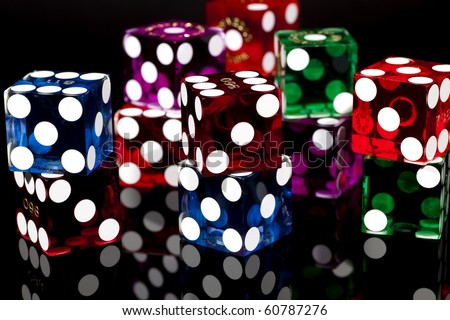 Colorful pairs of casino gaming/gambling dice isolated on a black background with reflection.