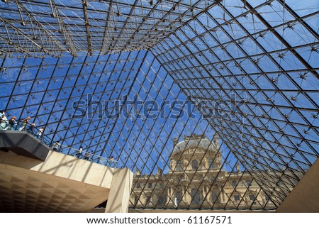 PARIS - JULY 11: A view to the blue sky from underneath the glass Pyramid in the Louvre Museum with visitors and the Richelieu wing in the background on July 11, 2010 in Paris.