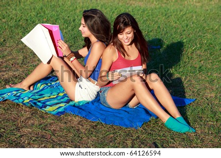 Pretty multicultural college teenagers studying outdoors on a university campus.