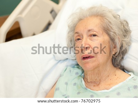 Elderly 80 year old woman with Alzheimer\'s in a hospital bed.
