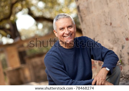 Handsome middle age man with gray hair in an outdoor setting.