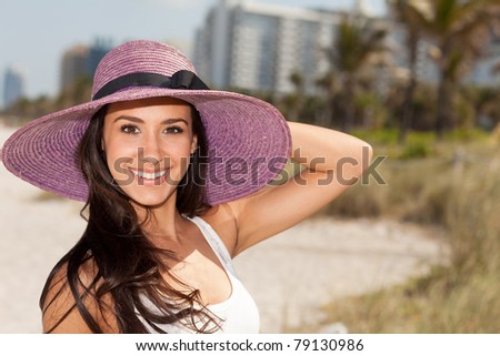 Beautiful young woman wearing a fancy purple hat and enjoying Miami\'s beautiful South Beach.
