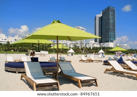 Colorful lounge chairs and umbrellas in popular South Beach in Miami.