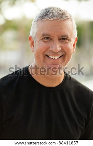 Handsome unshaven middle age man in an outdoor setting.
