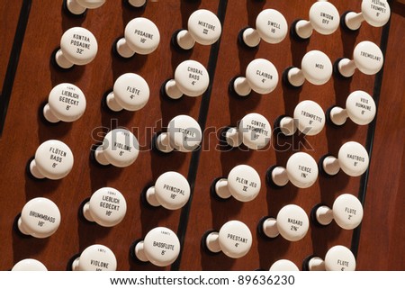 Close up view of the stop knobs of a church pipe organ.