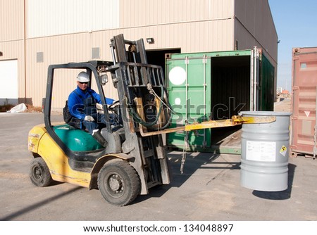 the worker on a loader loads a barrel with natural uranium