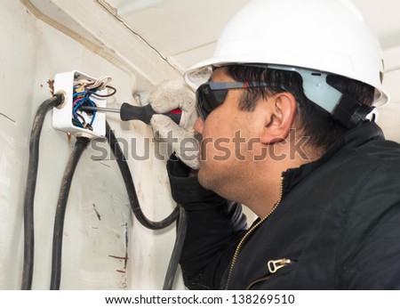 The electrician establishes an electrical wiring. Installation of equipment on production.