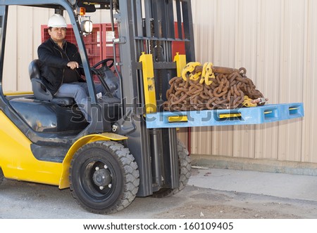 warehouse worker driver in uniform driving forklift stacker loader