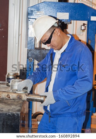 Industrial area. The mechanic works in a workshop.