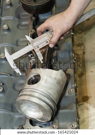 Industrial platform. The mechanic does detail measurement. Engine repair.