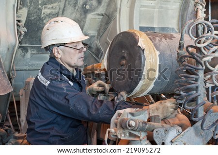 The technician repairs the industrial mechanism