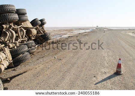 A view of an overturned truck on an desert in an accident