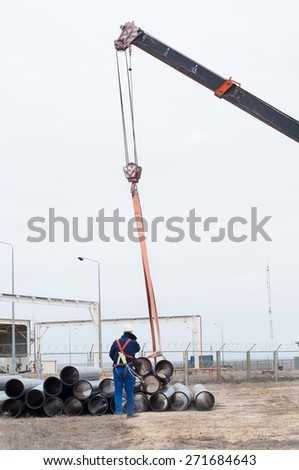 Unloading of pipes, crane works. Industrial zone.