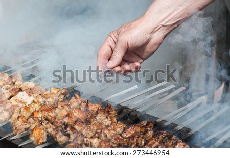 Shish kebab in process of cooking on open fire outdoors