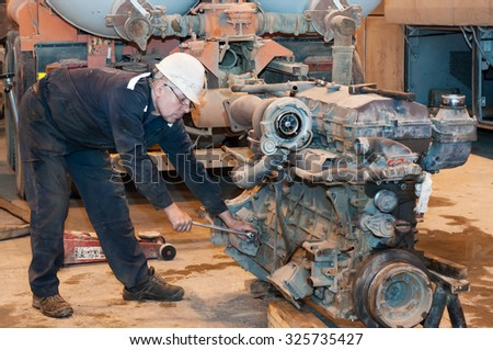 The car mechanic repairs the truck engine