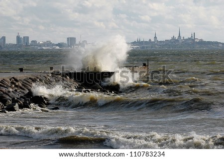 Storm on sea. Estonian capital Tallinn at background