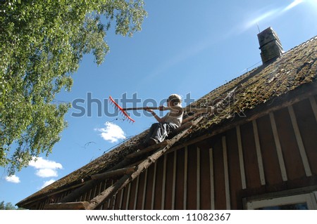 young boy does cleaning work on the roof