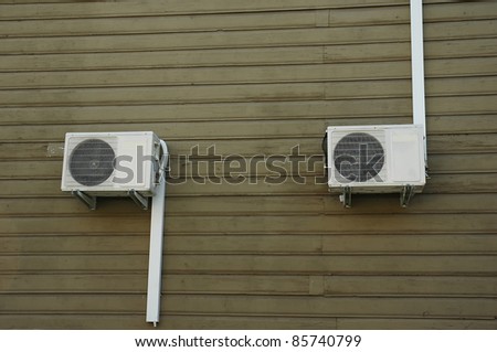 Two external air-conditioner units mounted outside on a wall