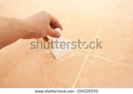 Work with a putty knife - process of laying of a ceramic tile