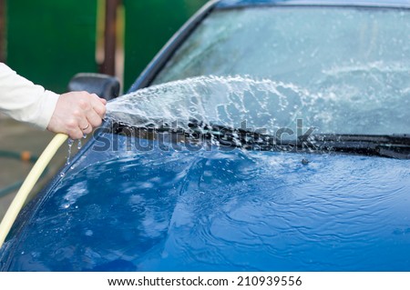 The process of washing cars with a hose with water in the yard